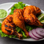 tandoori chicken is chicken dish prepared by roasting chicken marinated yogurt spices tandoor clay oven served with onion green chutney scaled